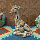 Cast marble of a giraffe calf painted in it's tradition orange and tan coloring.