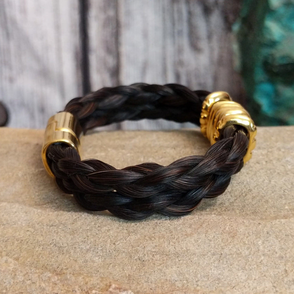 A braided dark brown horsehair bracelet with gold-toned accents and a magnetic clasp.