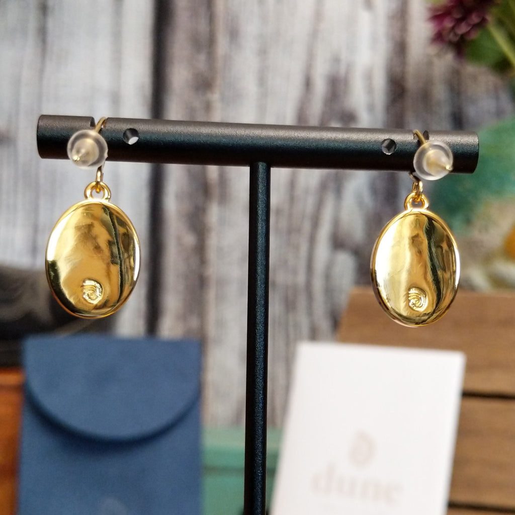 Gold-plated brass backings of the earrings with the Dune Jewelry trademark.