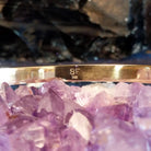 The maker's initials are etched into the underside of the cuff.