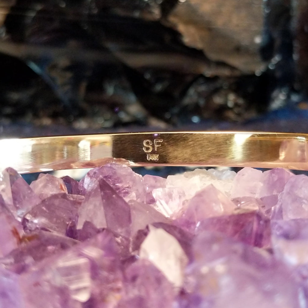 The maker's initials are etched into the underside of the cuff.