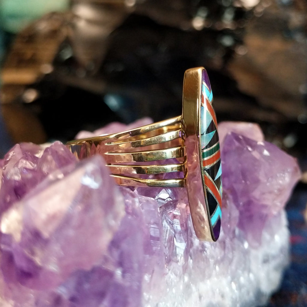 Gold ring featuring a multi-stone inlay set in a gold multiband.