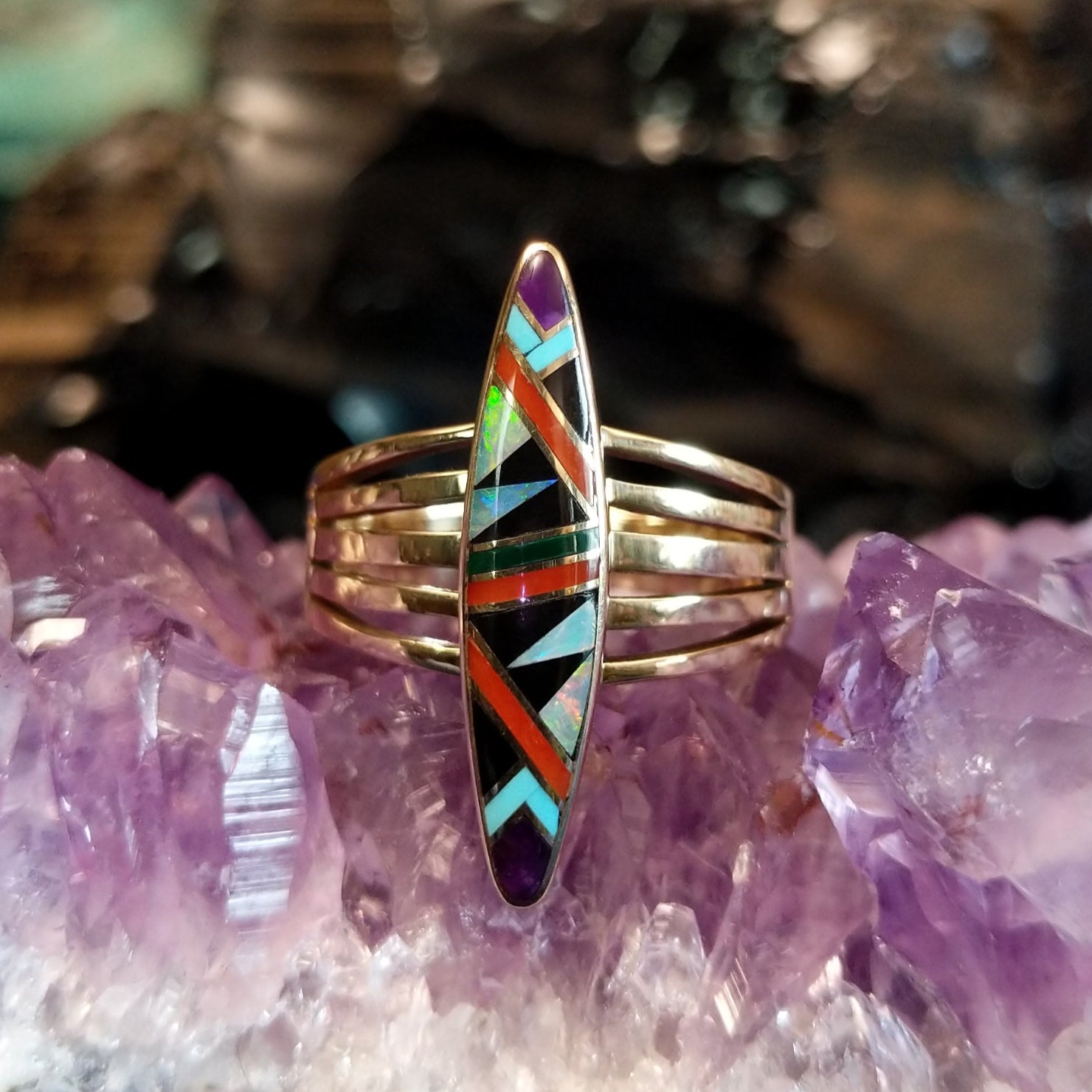 Gold ring featuring a multi-stone inlay set in a gold multiband.