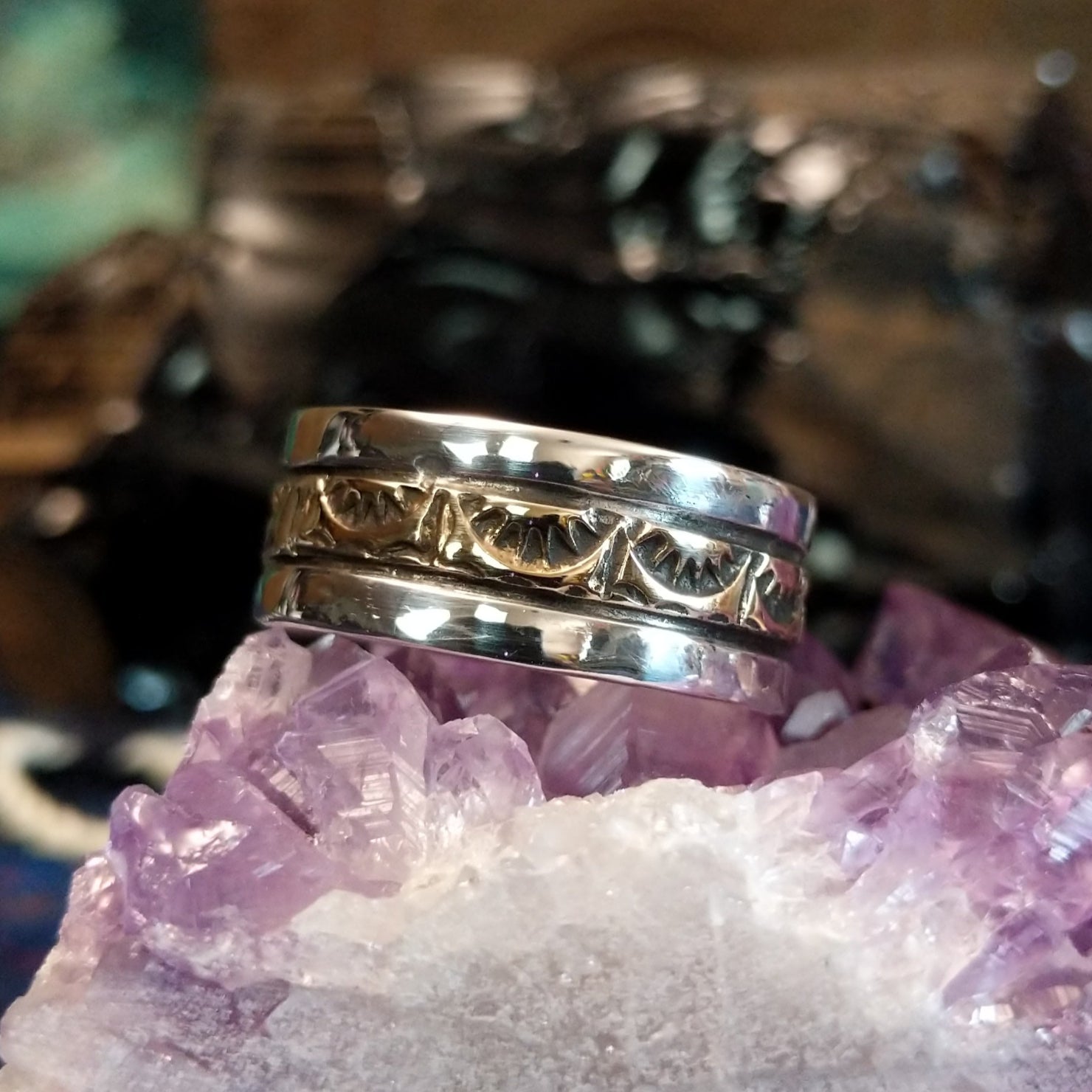A sleek gold and silver ring featuring intricate designs.