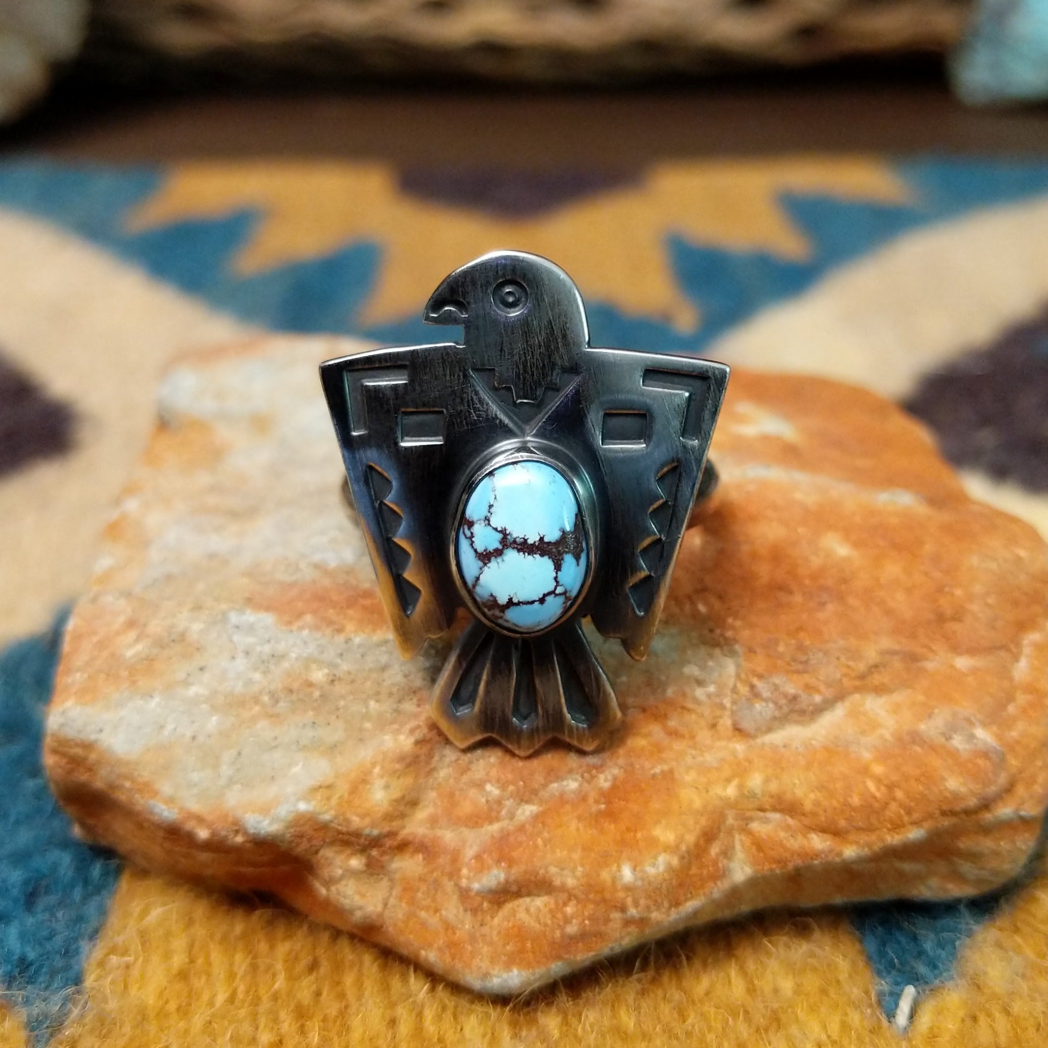 Handcrafted Navajo sterling silver Thunderbird ring by Lowell Draper featuring an oval Golden Hill turquoise cabochon with natural dark matrix, set in a traditional hand-cut Thunderbird design with an oxidized finish.