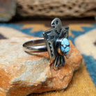 Handcrafted Navajo sterling silver Thunderbird ring by Lowell Draper featuring an oval Golden Hill turquoise cabochon with natural dark matrix, set in a traditional hand-cut Thunderbird design with an oxidized finish; side view.