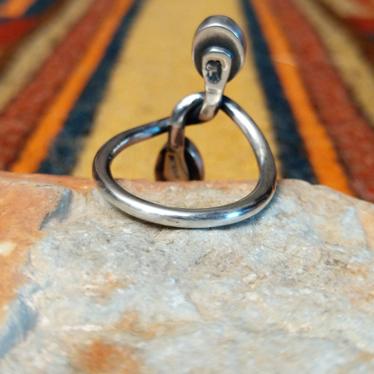 Golden Hills Turquoise Ring by Raymond Coriz featuring two oval light blue turquoise stones with natural matrix, set at opposite ends of a polished silver band with an elegant, flowing design; underside view.
