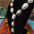 Golden Hills turquoise necklace by Randall Endito with linked scalloped silver settings and three descending center stones.