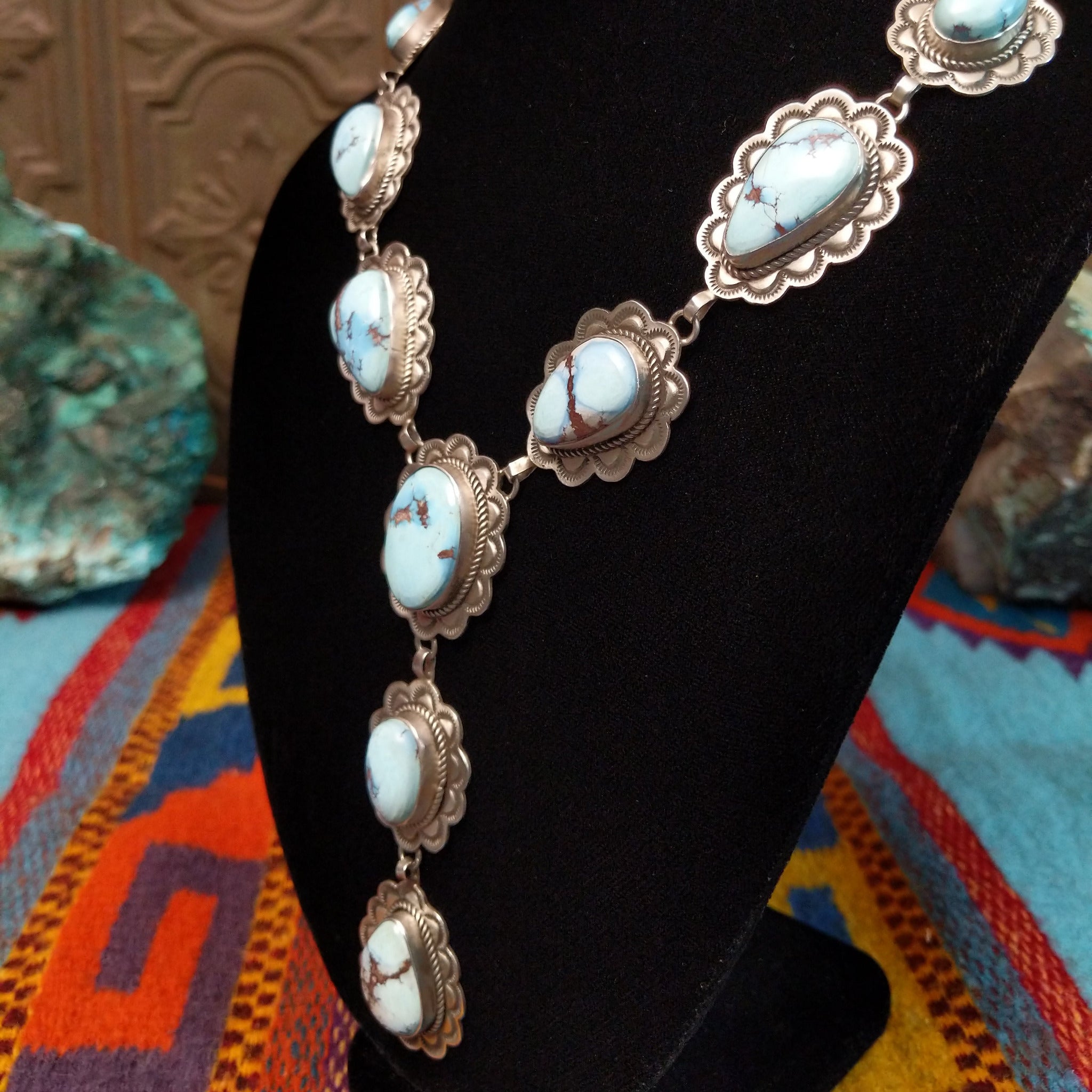 Golden Hills turquoise necklace by Randall Endito with linked scalloped silver settings and three descending center stones.