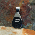 The back of the pendant shows the stamped signature on the back of the sterling silver pendant.