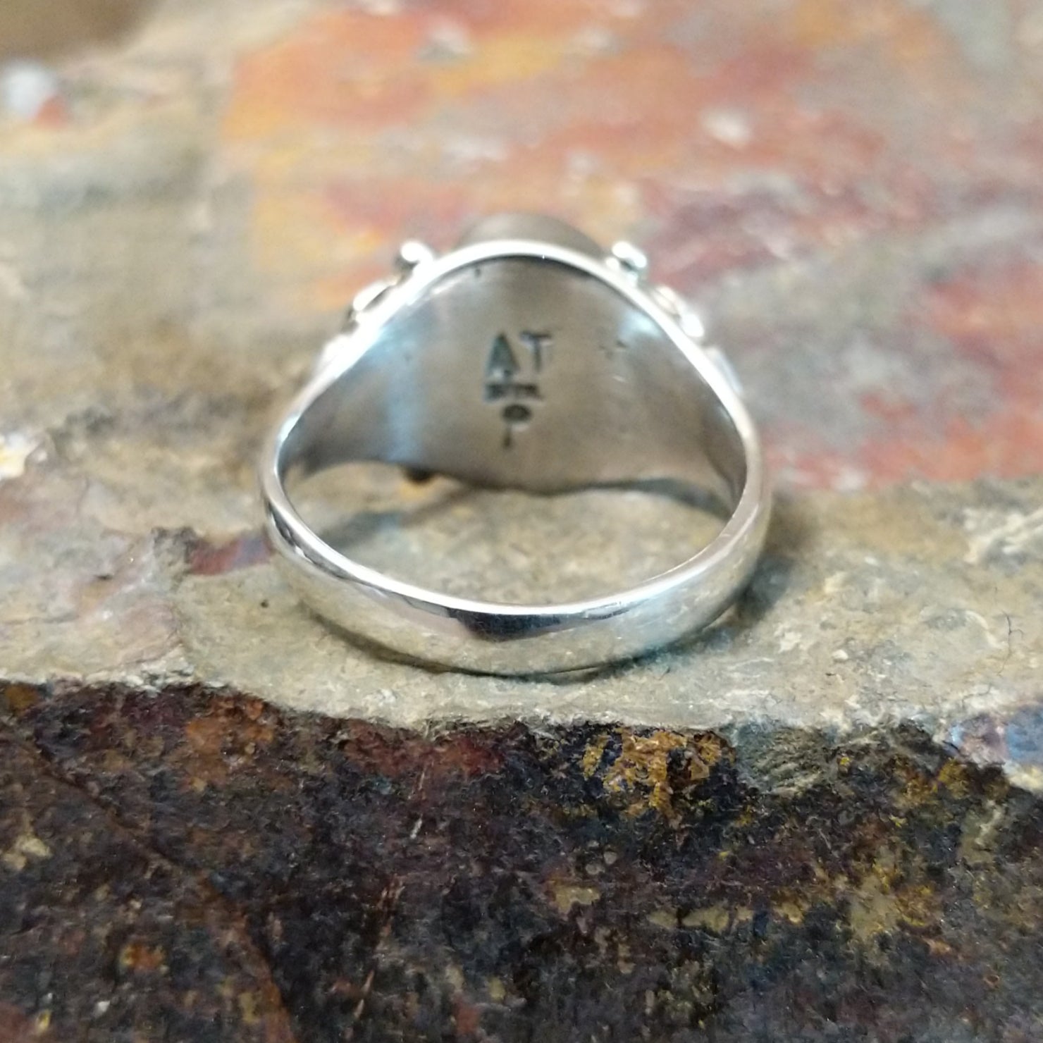 Silver ring with signature on the inner band, no stones or decoration present.