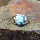 Silver ring with a round Golden Hills turquoise stone in a smooth bezel, adorned with decorative silver accents.