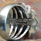 Silver ring with stamped signature on the inner band. No stones or decorations present.