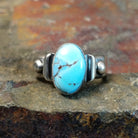 Silver ring with an oval Golden Hills turquoise stone in a smooth bezel, accented by silver bead details.
