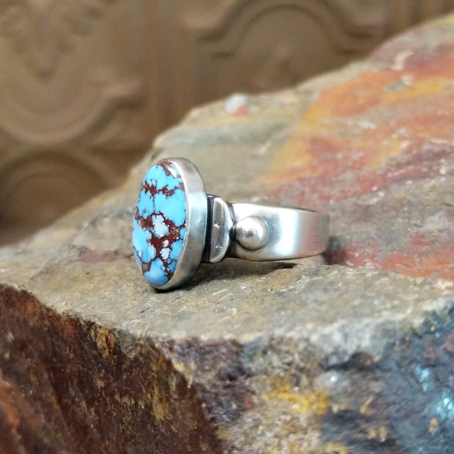 The ring’s band features polished silver with subtle silver ball accents.