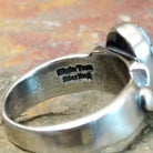A clear brand signature is etched into the silver.
