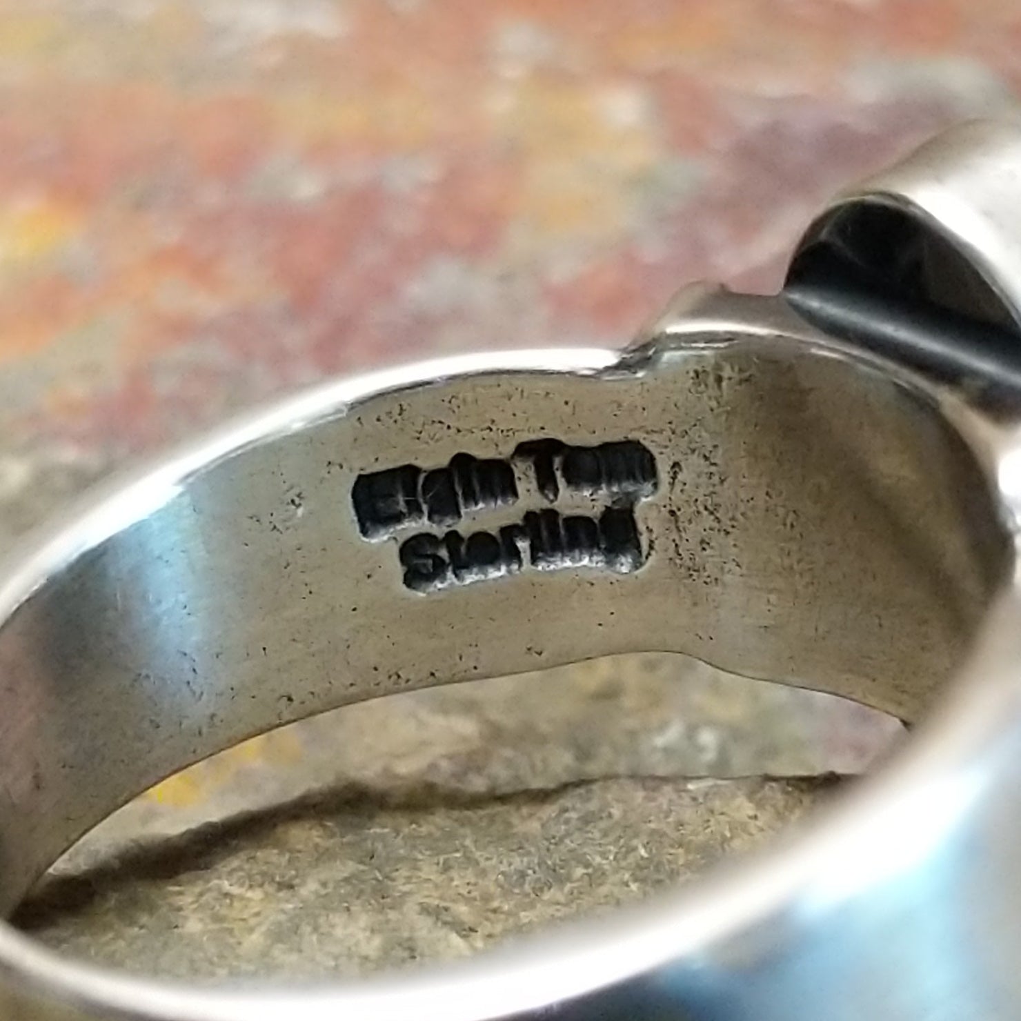 Silver ring with stamp and signature on the inner band, no stones or decoration present.
