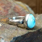 Triangular turquoise bezel set on a textured silver band.
