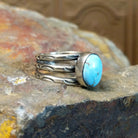 The ring’s multi-band design showcases polished silver with ribbed detailing.