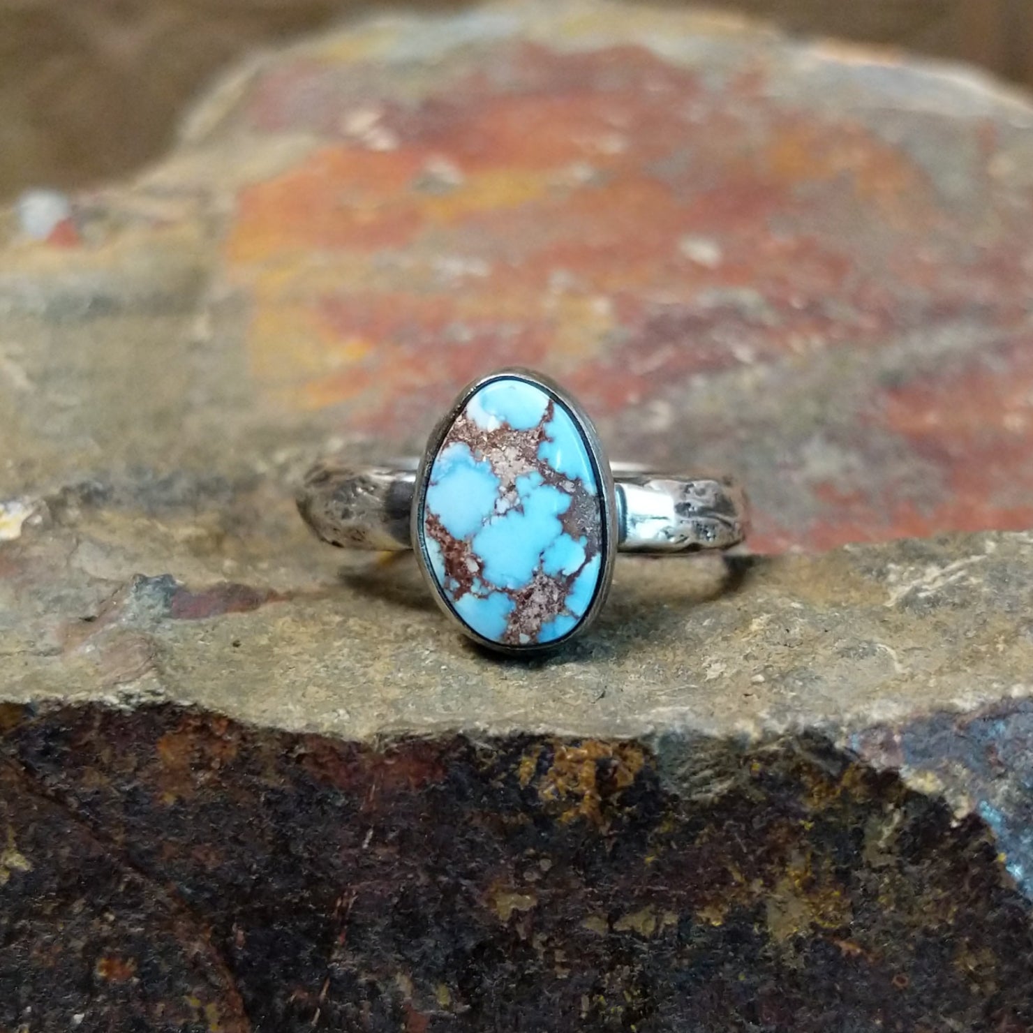 Golden Hills turquoise stone with prominent matrix veining sits in a smooth silver bezel, framed by a textured band.