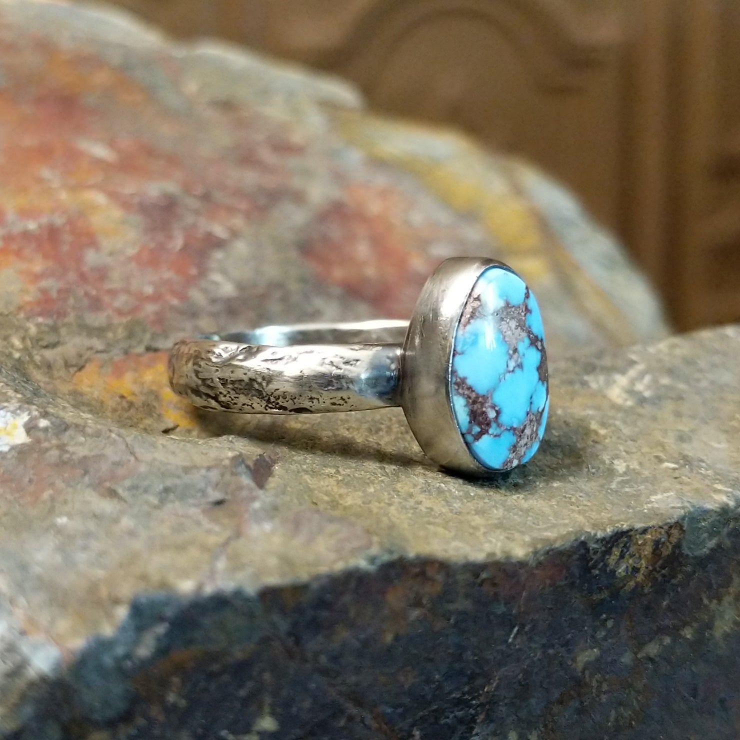 The ring’s band features a textured silver finish.