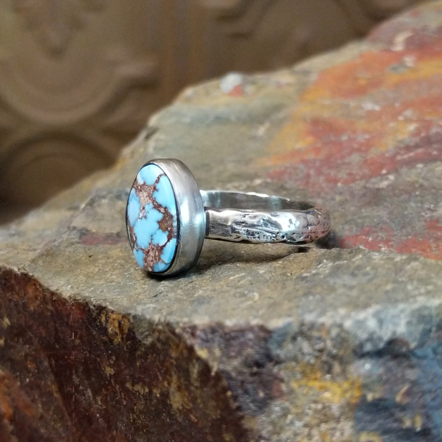 The ring’s band features a textured silver finish.