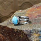 The ring’s multi-band design showcases polished silver with ribbed detailing.