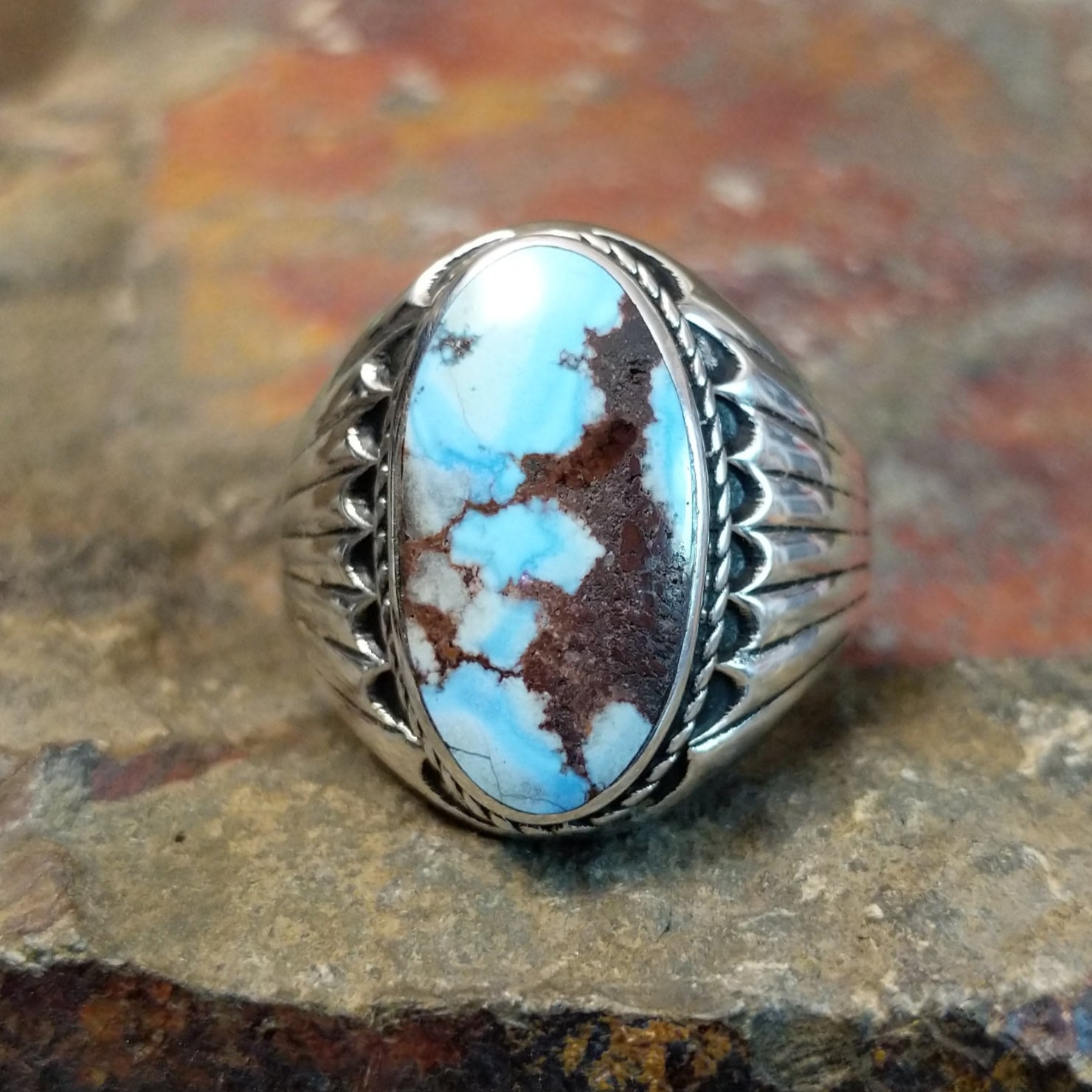 A striking oval Golden Hills turquoise stone with rich matrix veining sits in a smooth silver bezel, framed by twisted rope accents.