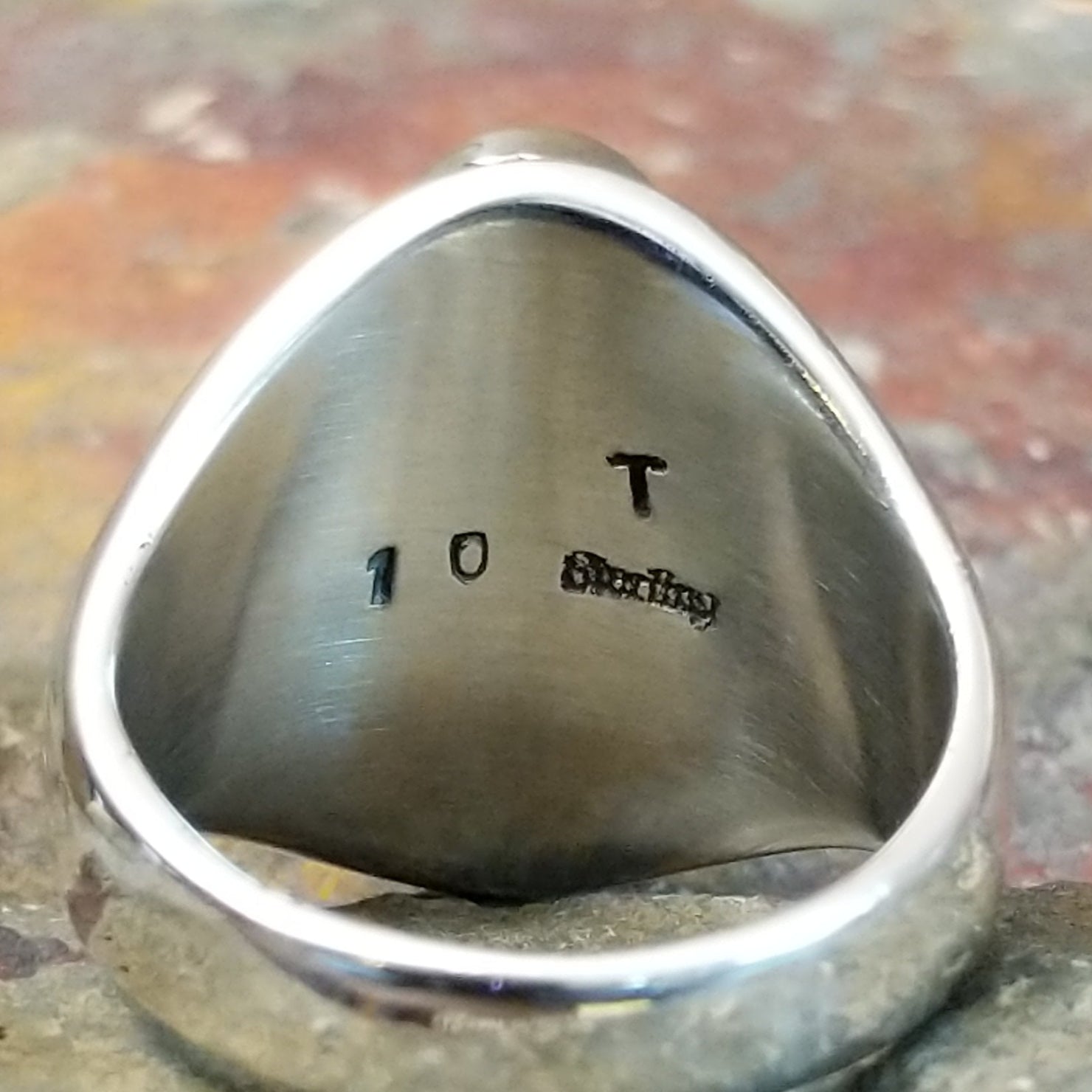 A clear brand signature is etched into the silver.