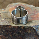 The band design showcases polished silver with ribbed detailing.