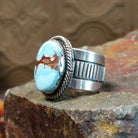 The band design showcases polished silver with ribbed detailing.