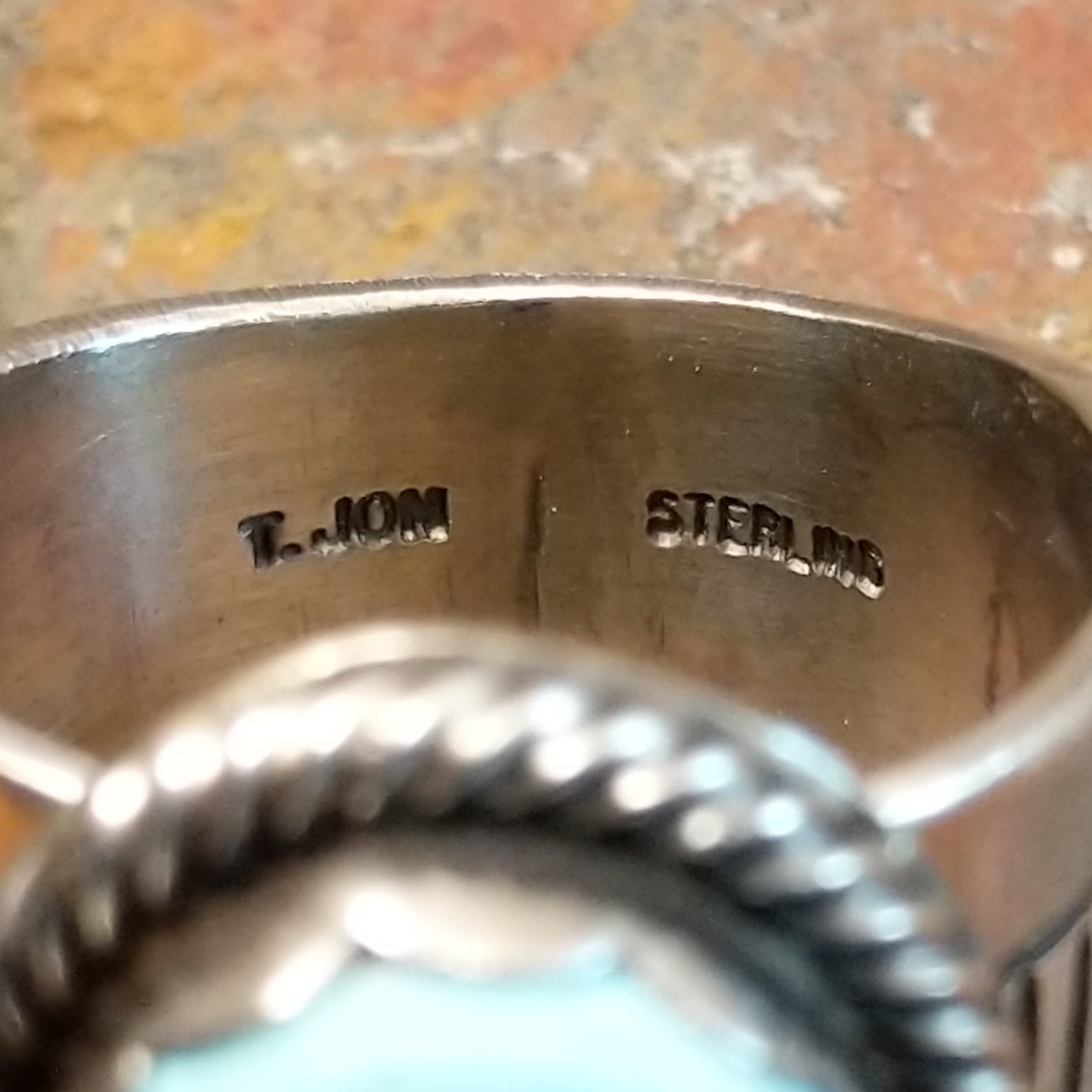 The clear signature is etched into the silver.