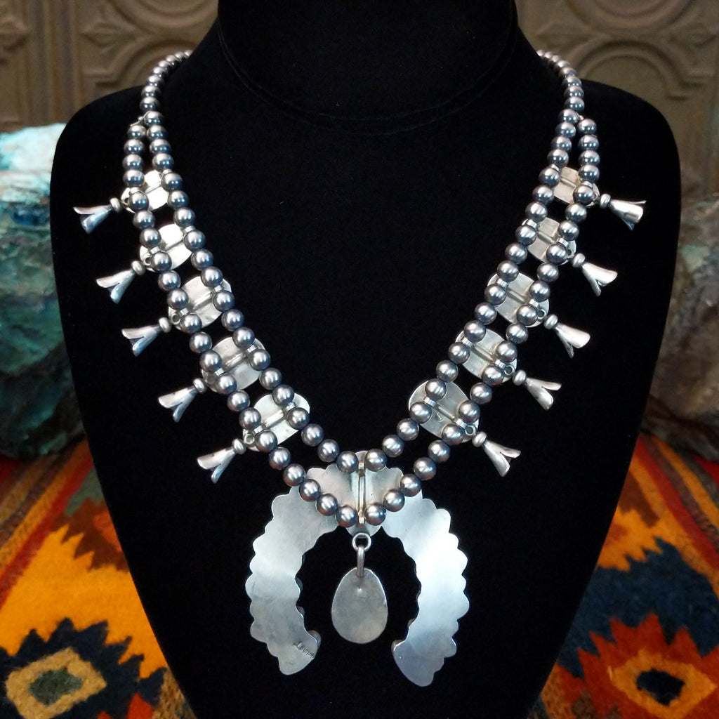 Necklace with naja pendant and beads all along the back.