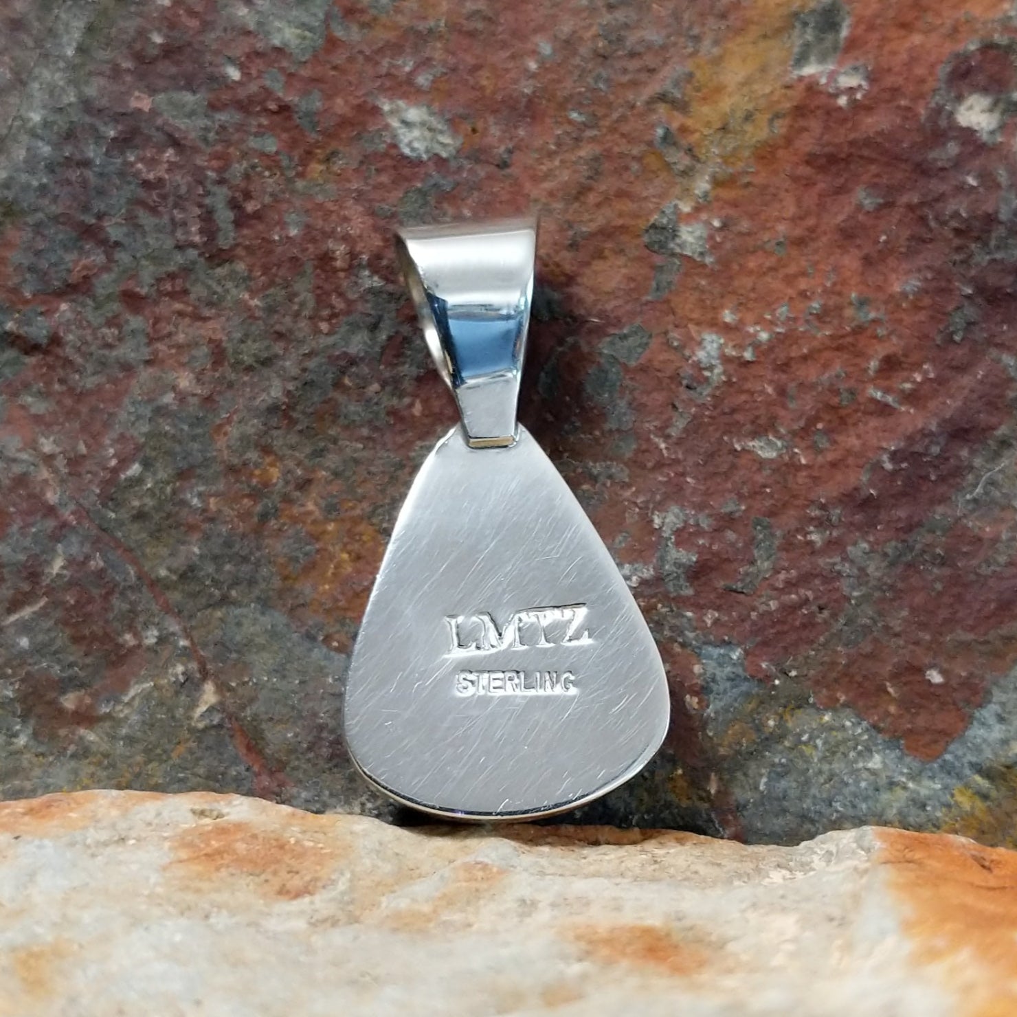 The stamped/signature view features a small hallmark, marking Leon Martinez’s artistry on the sterling silver backing.