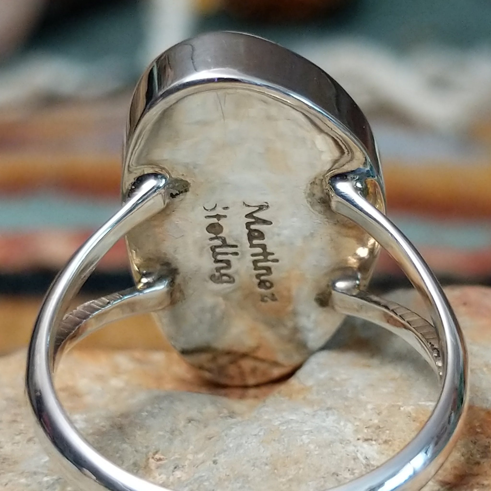 Sterling silver ring by Sheryl Martinez featuring an elongated oval White Buffalo stone with subtle dark veining and an elegant split-shank band; artisan and Sterling Silver stamp.