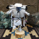 Navajo-made hoop dancer kachina doll by M. C. with blue mask, white feathers, and interwoven black hoops.