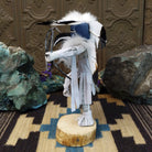 Navajo-made hoop dancer kachina doll by M. C. with blue mask, white feathers, and interwoven black hoops.