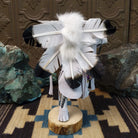 Navajo-made hoop dancer kachina doll by M. C. with blue mask, white feathers, and interwoven black hoops.