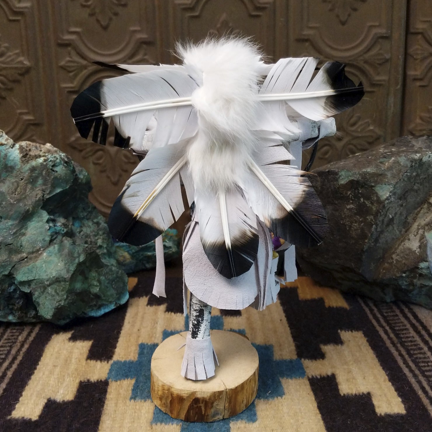 Navajo-made hoop dancer kachina doll by M. C. with blue mask, white feathers, and interwoven black hoops.