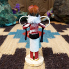 Mini hoop dancer kachina by Rosalind Grey with white hoops, white fur collar, red body, and white geometric-patterned garment.