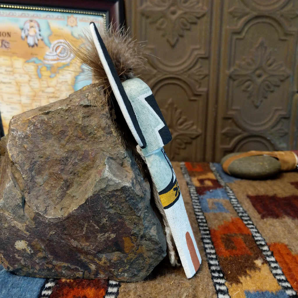 Wood carved into a crow mother kachina featuring tradition style of black and white paints with pop of colors and a feather at the top of the head.