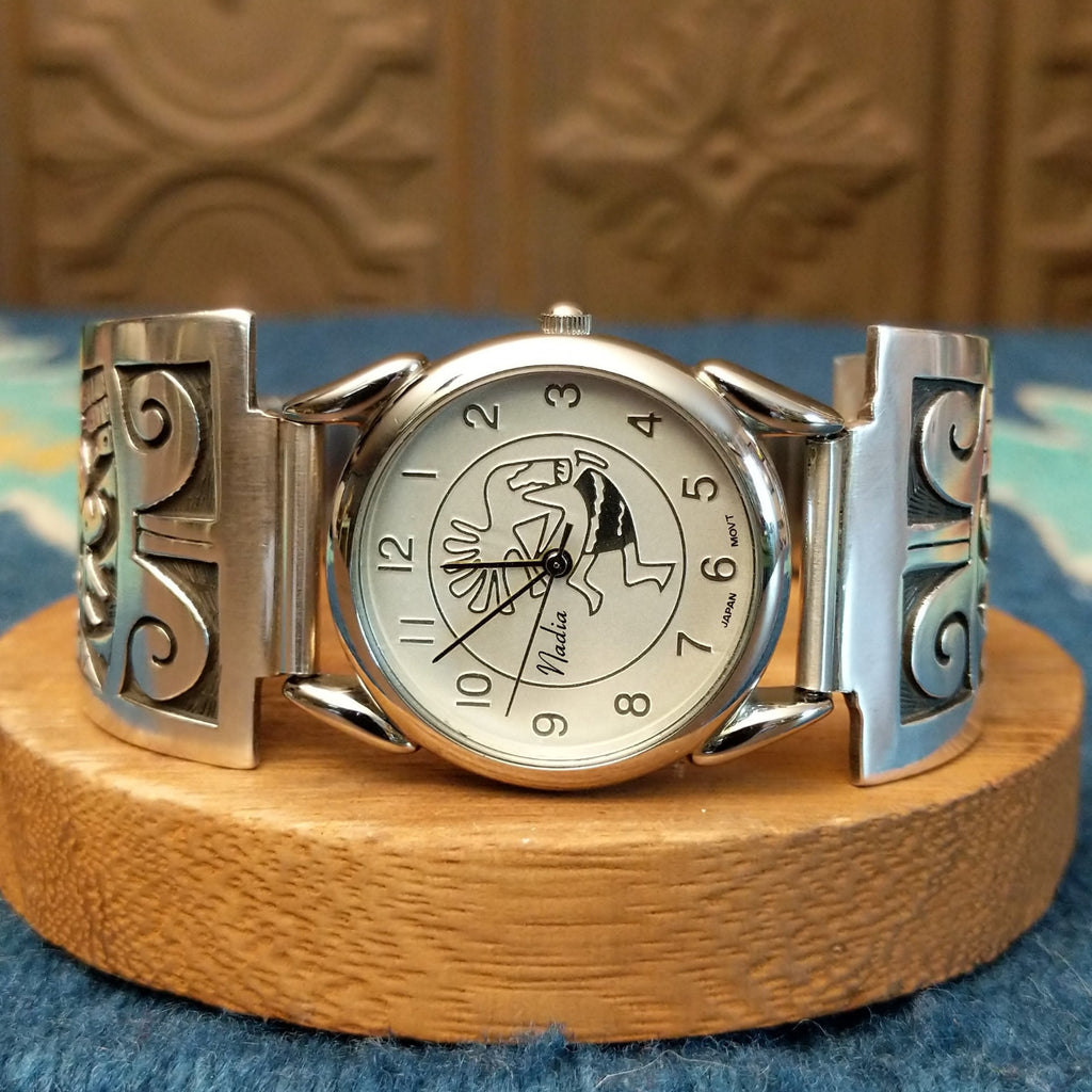 Sterling silver and stainless steel watch with ornate flute player detail and intricate watch face.