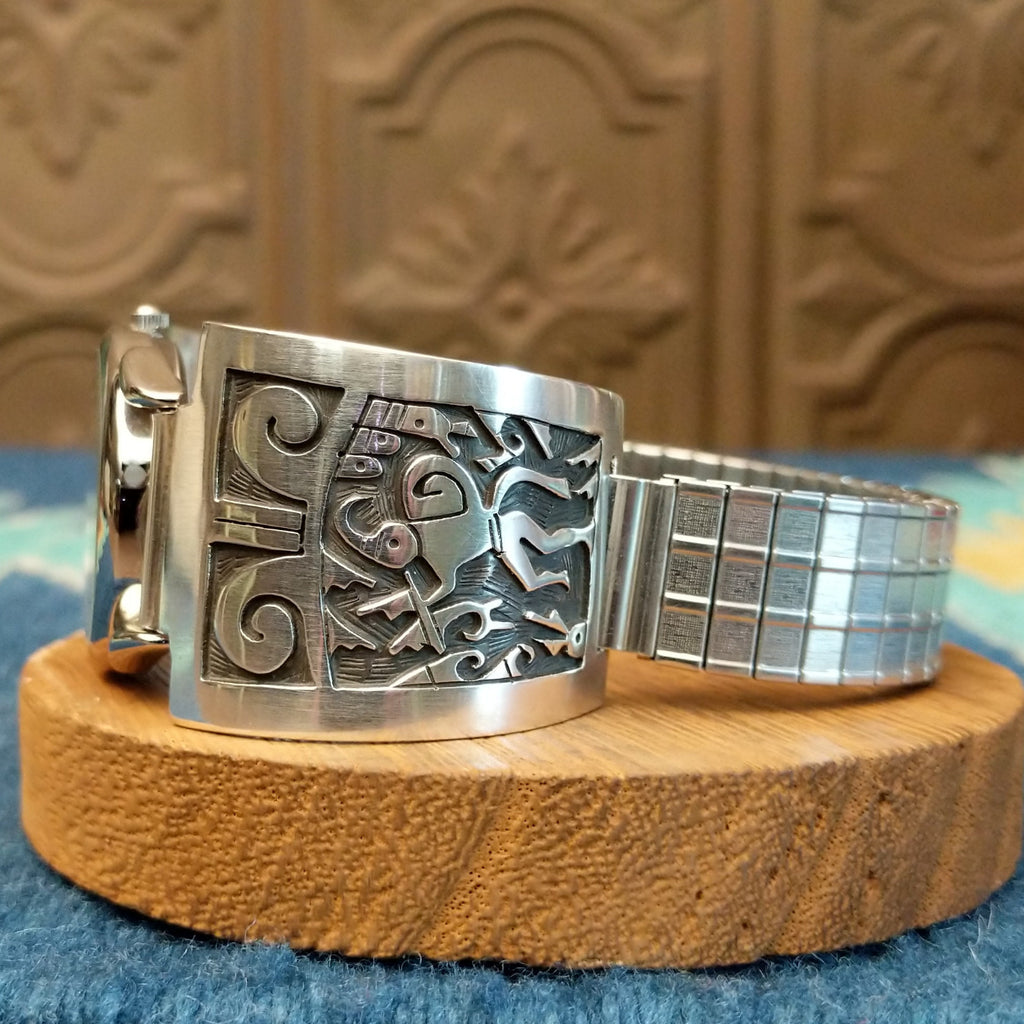 Sterling silver and stainless steel watch with ornate flute player detail and intricate watch face.