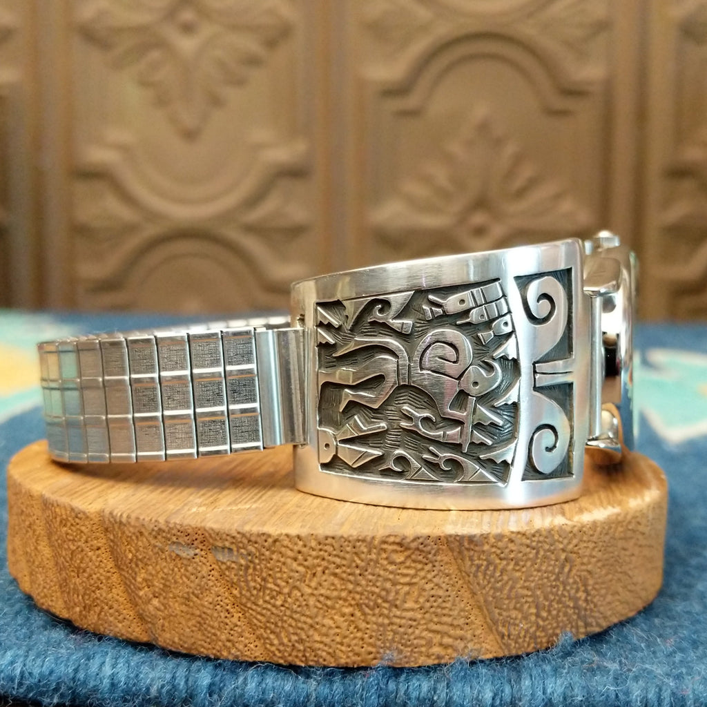 Sterling silver and stainless steel watch with ornate flute player detail and intricate watch face.