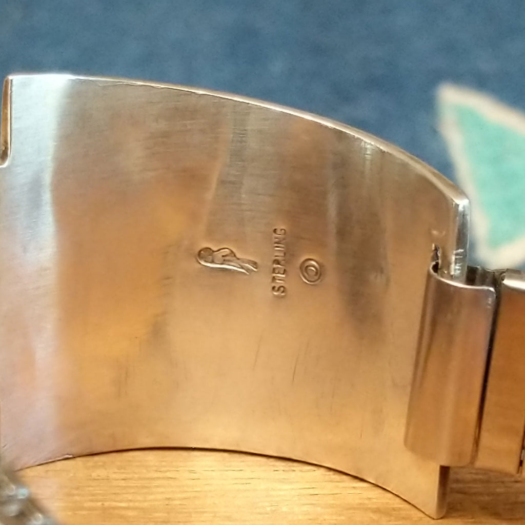 Close-up of the artisan's stamp on the interior of the watch.
