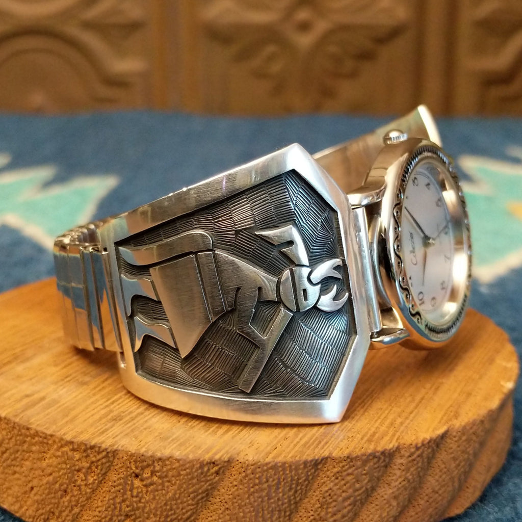 Sterling silver and stainless steel watch with ornate detailing on the bezel and flute players on the bracelet.