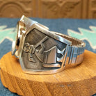 Sterling silver and stainless steel watch with ornate detailing on the bezel and flute players on the bracelet.