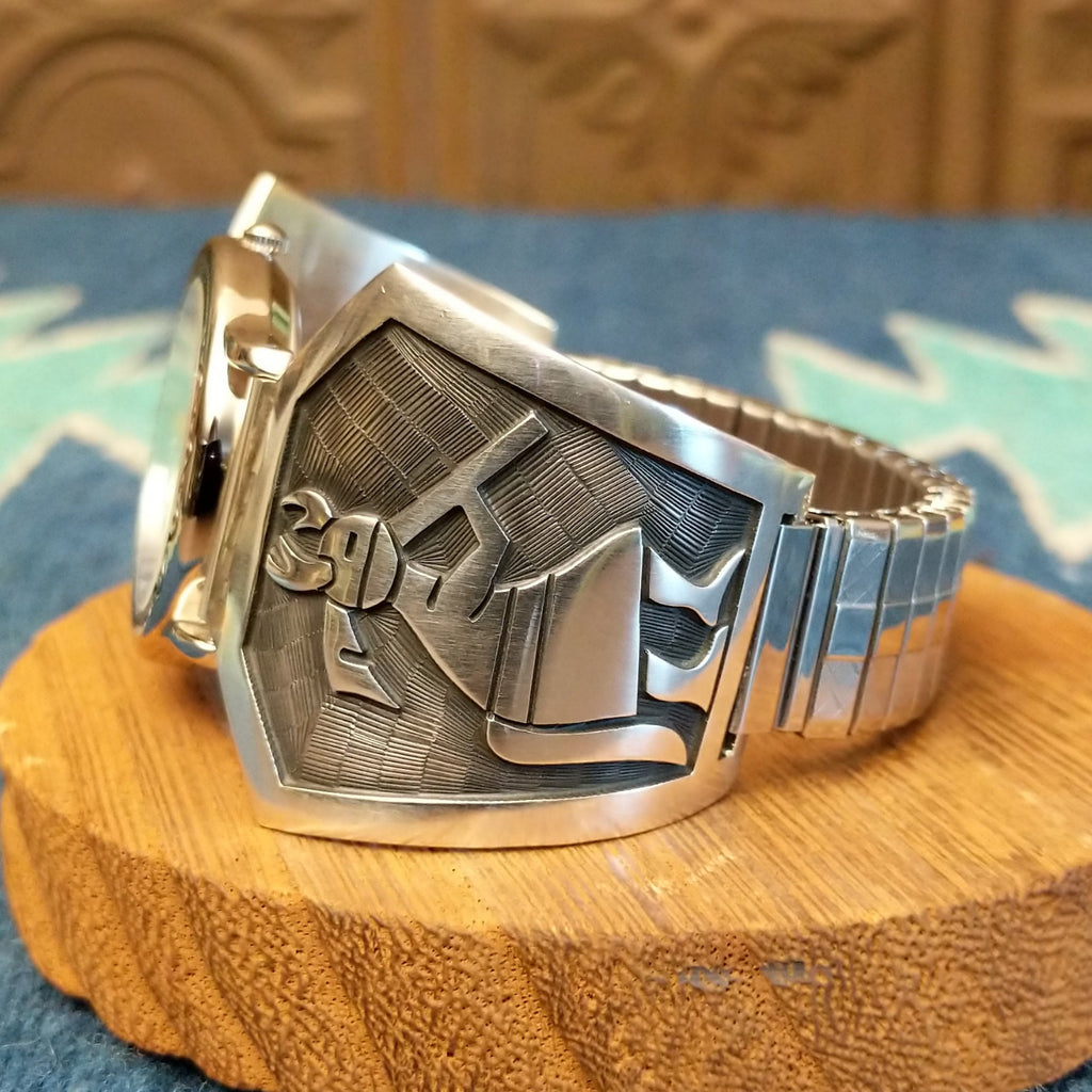 Sterling silver and stainless steel watch with ornate detailing on the bezel and flute players on the bracelet.