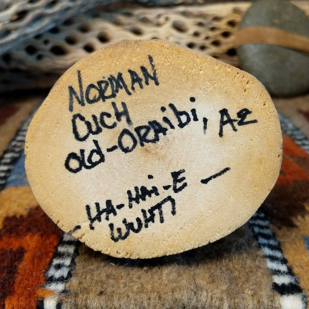 The underside of the base features the artisan's signature and information about the piece.