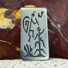 Sterling silver face with etching of a figure with a maize plant.